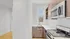 Modern kitchen with sleek stainless steel appliances, stylish cabinetry, and bright natural light through a large window.