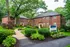Charming brick apartment buildings amidst lush greenery, offering two-bedroom apartments with inviting pathways and vibrant landscaping.