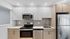 Modern kitchen featuring sleek stainless steel appliances, elegant white cabinetry, and a compact layout.