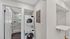 Modern apartment featuring a sleek in-unit laundry area with state-of-the-art stacked washer and dryer next to a chic bathroom entrance.