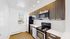 Modern kitchen with sleek dark wood cabinets, stainless steel appliances, and bright white backsplash, ensuring a stylish cooking space.