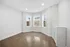 Bright and inviting room featuring large windows with city views and elegant wood flooring.