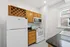 Charming kitchen with sleek appliances, elegant wooden cabinets, and a built-in wine rack, filled with natural light.