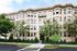 Charming historic apartment building with elegant architecture and lush greenery in a vibrant neighborhood.