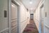 Modern apartment hallway featuring colorful carpet and sleek doors, offering a welcoming and stylish entrance.