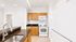 Elegant modern kitchen with sleek granite countertops, wooden cabinets, and white appliances for a sophisticated touch.