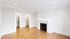Bright apartment room with elegant wooden floors, classic white fireplace, and spacious walk-in closet.