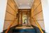 Elegant apartment entrance with modern wooden doors, warm lighting, and sleek tiled walls creating a welcoming ambiance.