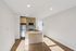 Modern kitchen with sleek wooden cabinetry, stainless steel appliances, and a stylish peninsula, bathed in natural light.