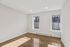 Bright and airy room with large windows, hardwood floors, and elegant white walls, perfect for a serene living space.