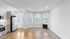 Bright, modern kitchen with stainless steel appliances, hardwood floors, and large bay windows offering a beautiful view.
