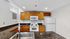 Modern kitchen with elegant granite countertops, wooden cabinets, and contemporary appliances.