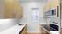 Modern kitchen with sleek stainless steel appliances, elegant herringbone backsplash, and bright natural light.