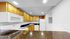 Modern kitchen with sleek black countertops, warm wooden cabinets, and white appliances, creating a cozy and functional space.