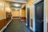 Charming apartment hallway with elegant moldings and warm-toned walls, featuring stylish black doors and modern lighting.