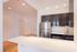 Modern kitchen with sleek stainless steel appliances, elegant dark wood cabinetry, and a spacious white countertop.