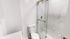 Elegant modern bathroom featuring a sleek glass-enclosed shower with marble accents and a pristine white toilet.