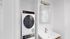 Modern bathroom with elegant vanity, sleek mirror cabinet, and integrated washer-dryer for ultimate convenience.