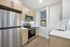 Modern kitchen with sleek stainless steel appliances, elegant cabinetry, and stylish herringbone backsplash.