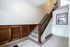 Charming staircase with rich wood paneling and elegant mosaic tile flooring, showcasing timeless architectural details.
