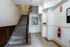 Inviting apartment lobby with elegant tiled flooring, classic wooden staircase, and modern safety features.