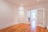Bright and inviting living space with classic hardwood floors and elegant French doors opening to a sunlit room.