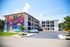 Nordica Flats, exterior, parking, entrances, stairs, three levels, mural, 'Dreamer' 'Welcome Home', woman and a setting sun on water