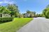 Welcoming view of Arbor Glade Apartments surrounded by lush greenery and clear blue skies.