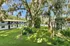 Charming courtyard view with lush greenery and a serene apartment building under soothing blue skies.