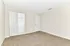 Bright and spacious bedroom with plush carpets and an open closet.