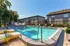 Inviting outdoor pool area surrounded by lounge chairs and lush greenery, offering a serene relaxation spot.