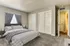 Elegant bedroom with plush bedding, soft carpeting, and ample closet space.