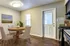 Inviting dining area with a round wooden table, elegant chairs, and a bright ceiling light.