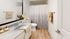Chic bathroom with modern fittings, featuring a sleek countertop, patterned shower curtain, and tasteful decor.