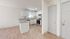 Bright kitchen with white cabinets, modern appliances, and light wood flooring.