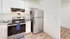 Modern kitchen with stainless steel appliances, sleek cabinets, and light hardwood flooring.