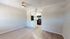 Bright, open-concept living area with modern kitchen featuring sleek appliances and elegant wood flooring.