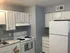 Cozy kitchen with white cabinetry, modern appliances, and elegant granite countertops.