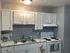 Charming kitchen with white cabinetry, modern appliances, and elegant marble countertops.