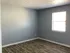 Bright and airy room with elegant laminate flooring and a large window, ideal for a cozy living space.