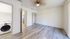 Bright and inviting room with modern flooring, ceiling fan, and in-unit laundry for convenient living.