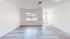Bright living space with sleek flooring and large windows offering abundant natural light, perfect for modern living.