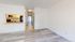Chic apartment interior showcasing open layout with a sleek granite countertop, light wood flooring, and inviting natural light.