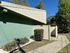 Modern apartment with a unique architectural design, featuring a fresh mint-green exterior and neatly landscaped entrance.