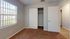 Bright and cozy bedroom with plush carpeting, spacious closet, and large window for natural light.