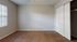 Bright and spacious bedroom with soft carpet flooring, large window, and ample closet space.