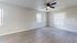 Spacious, modern room with elegant wood flooring and ceiling fan, perfect for creating your dream living space.