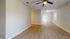Inviting open living space with beautiful hardwood floors and a modern ceiling fan, perfect for entertaining.