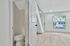 Modern apartment interior featuring sleek hardwood flooring, fresh white paint, and a bright, inviting space with a convenient half-bathroom.