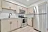 Modern kitchen with sleek stainless steel appliances, elegant light wood cabinets, and a polished granite countertop.